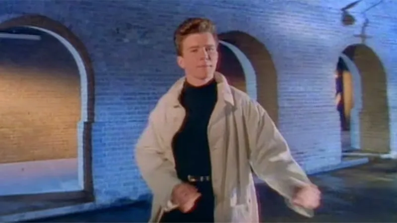 Rick Astley in the iconic Never Gonna Give You Up music video — the young red-haired singer whose 1987 hit became the internet's most famous bait-and-switch prank